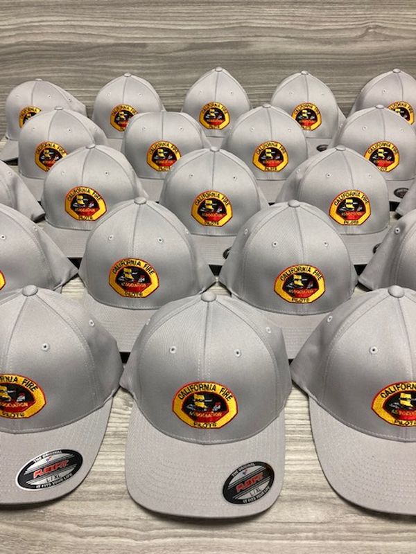 Rows of grey structured caps with an embroidered full-colour badge