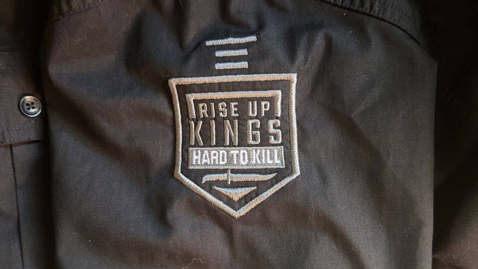 Embroidered chest patch stitched onto a dark work shirt