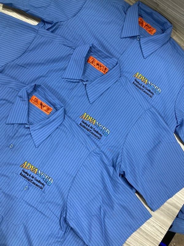 Blue embroidered work shirts for Advanced Heating and Air Conditioning, folded and stacked